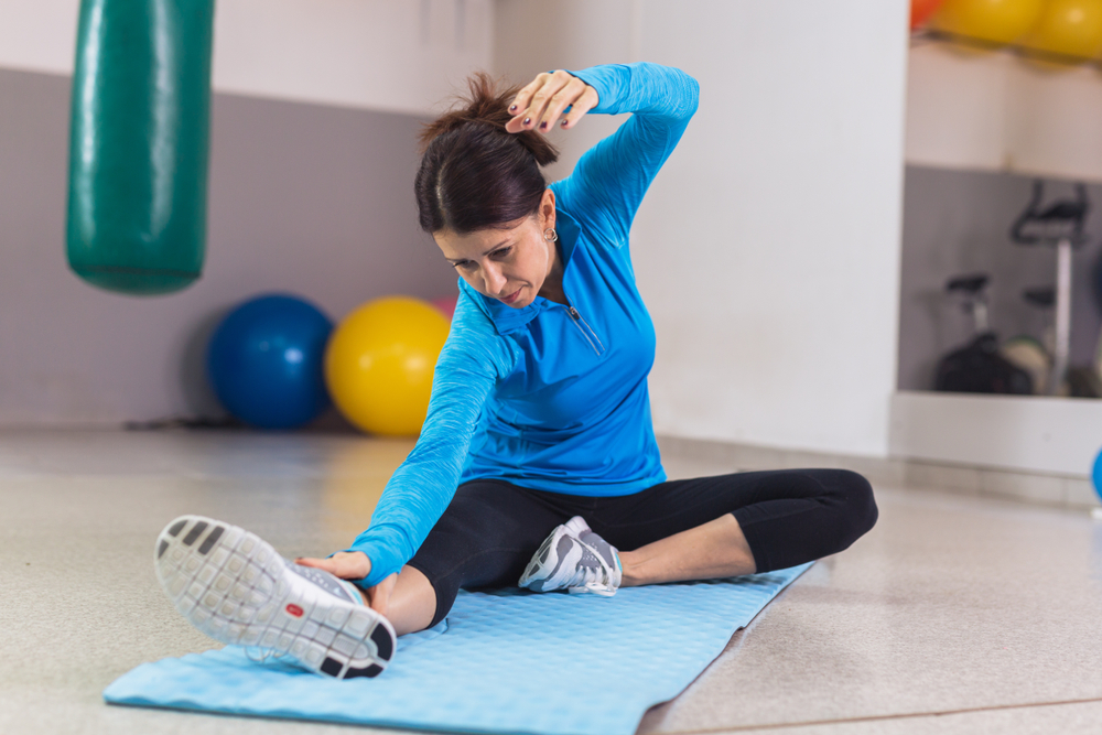 woman stretching on yoga mat